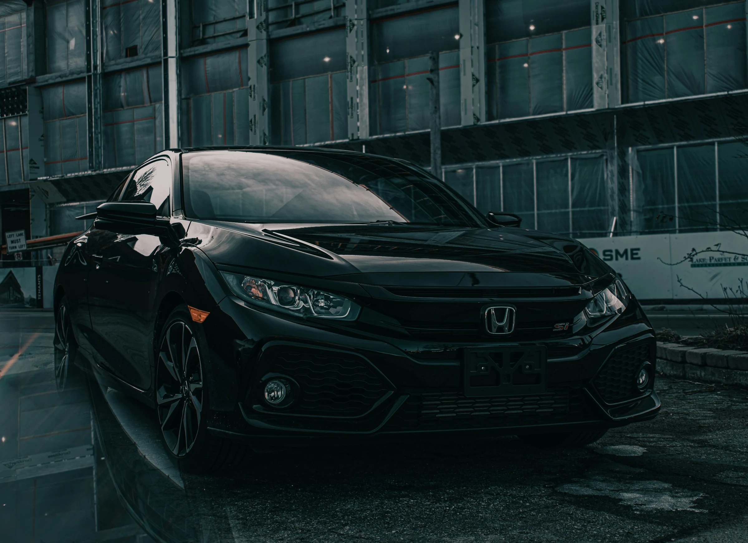 Black Honda Civic Si outside an industrial unit